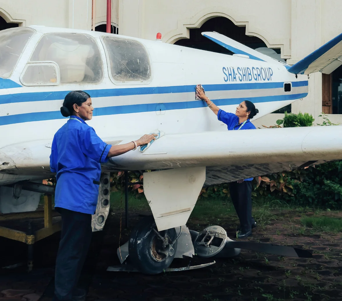 Two uniformed Supercare team members cleaning and maintaining an aircraft exterior at a client site in Bhopal