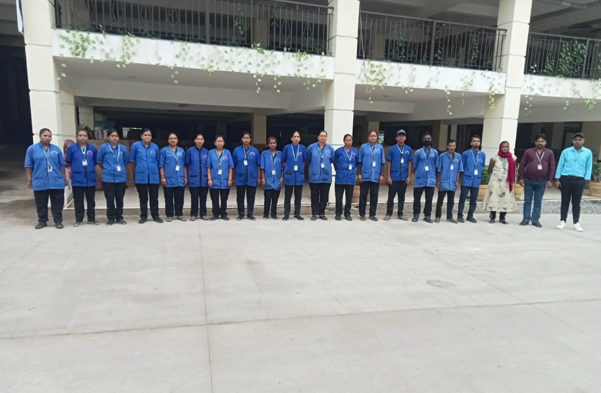 Row of uniformed Supercare housekeeping staff with ID lanyards at a client property