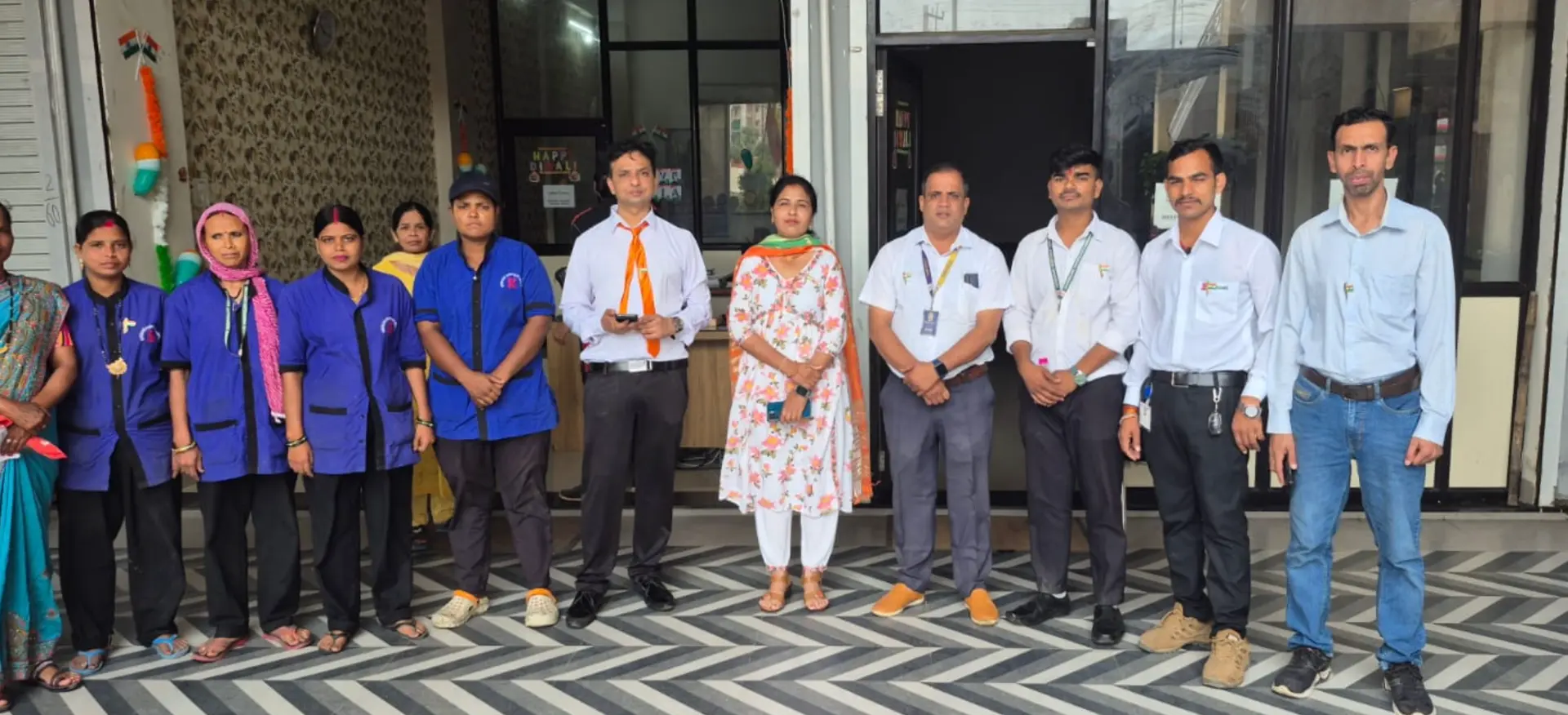 Supercare housekeeping staff and management team standing together at the office entrance
