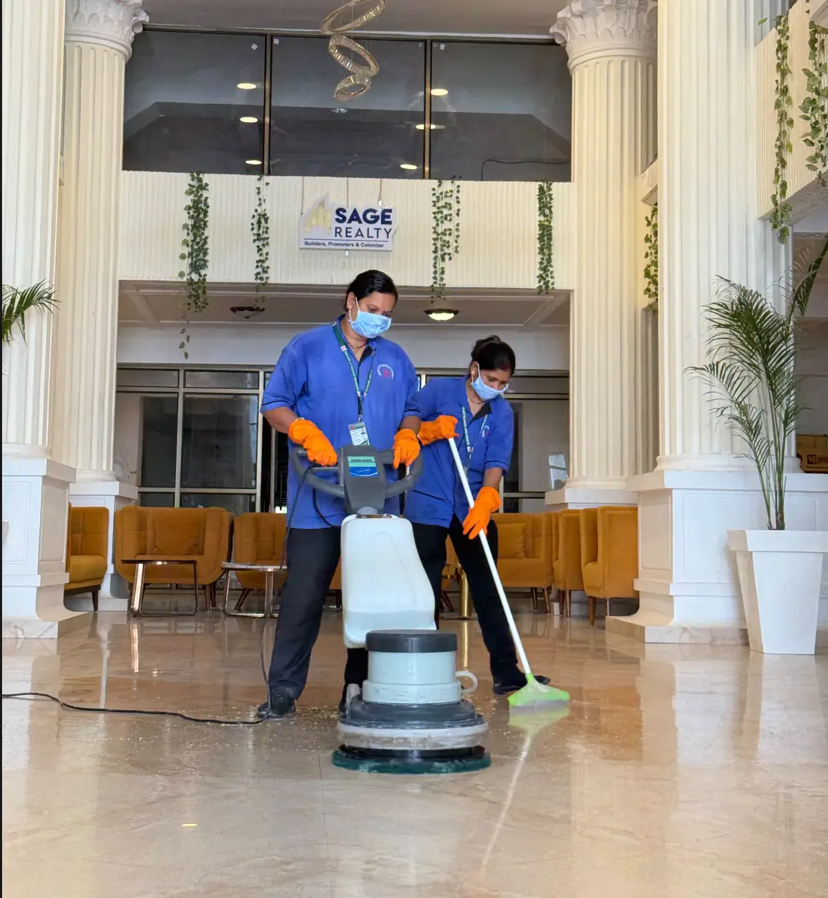 Two uniformed Supercare team members coordinating floor-care work at Sage Golden Spring in Bhopal